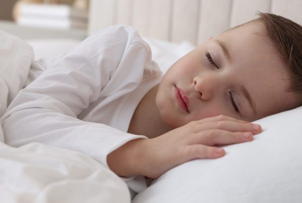 Young child sleeping peacefully in bed at night, representing childhood sleep and bedwetting concerns associated with ADHD