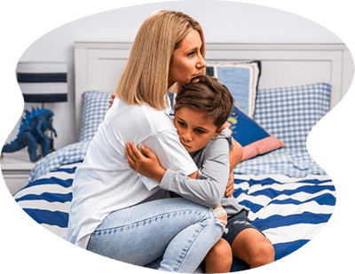 A Boy hugging his mom looking sad